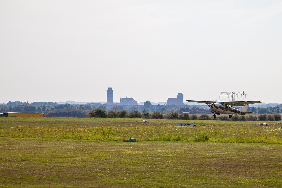 Flugzeug beim Start. Im Hintergrund die Silhouette von Wismar. (Author: Frank Burger)